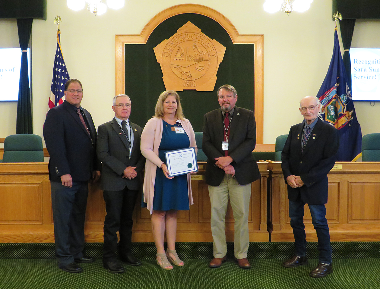 employee (Sara Sunday) receives certificate from legislators
